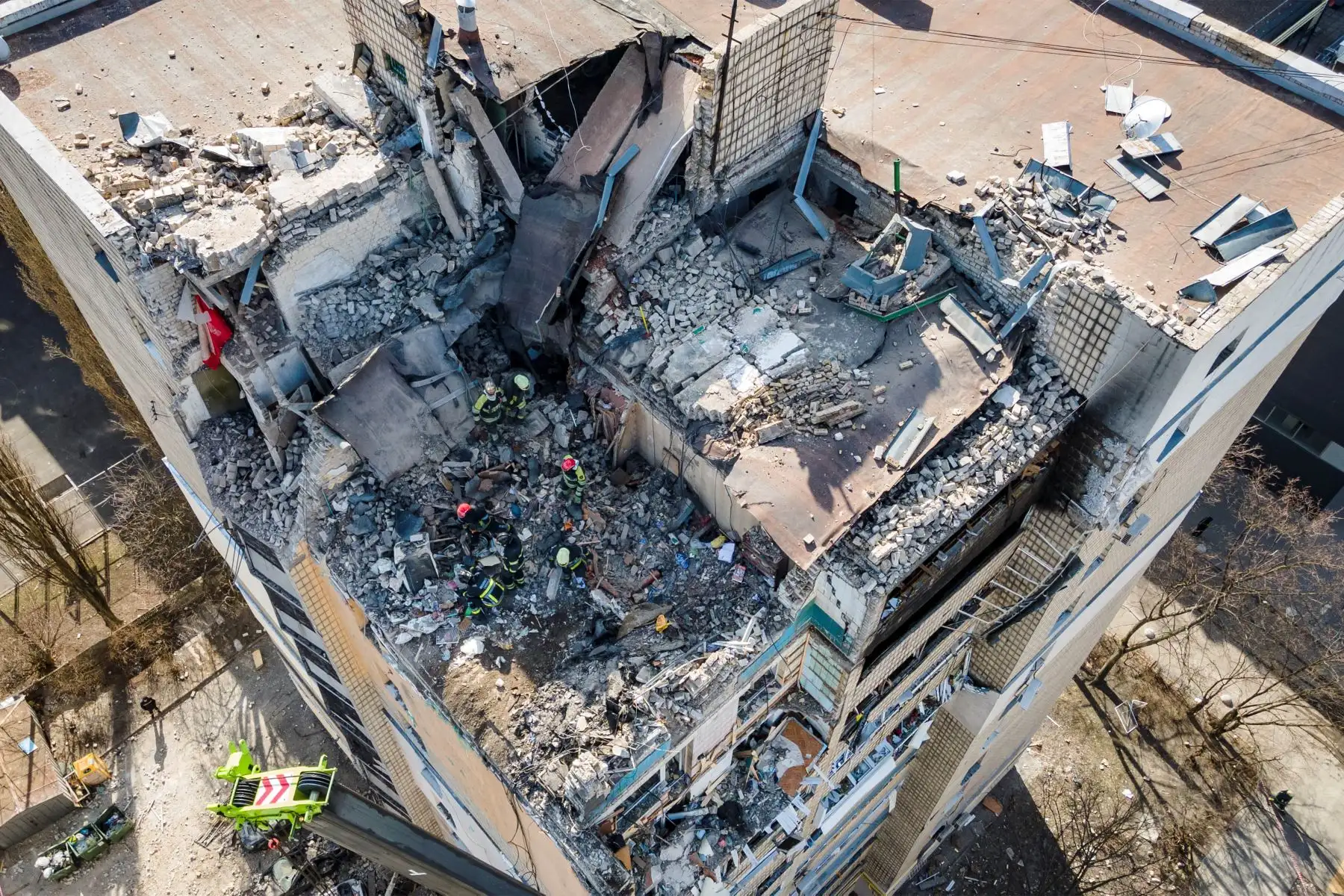 Vista aérea muestra a los bomberos trabajando entre los escombros de un edificio residencial que fue alcanzado por los escombros de un cohete derribado en Kiev. Foto: AFP