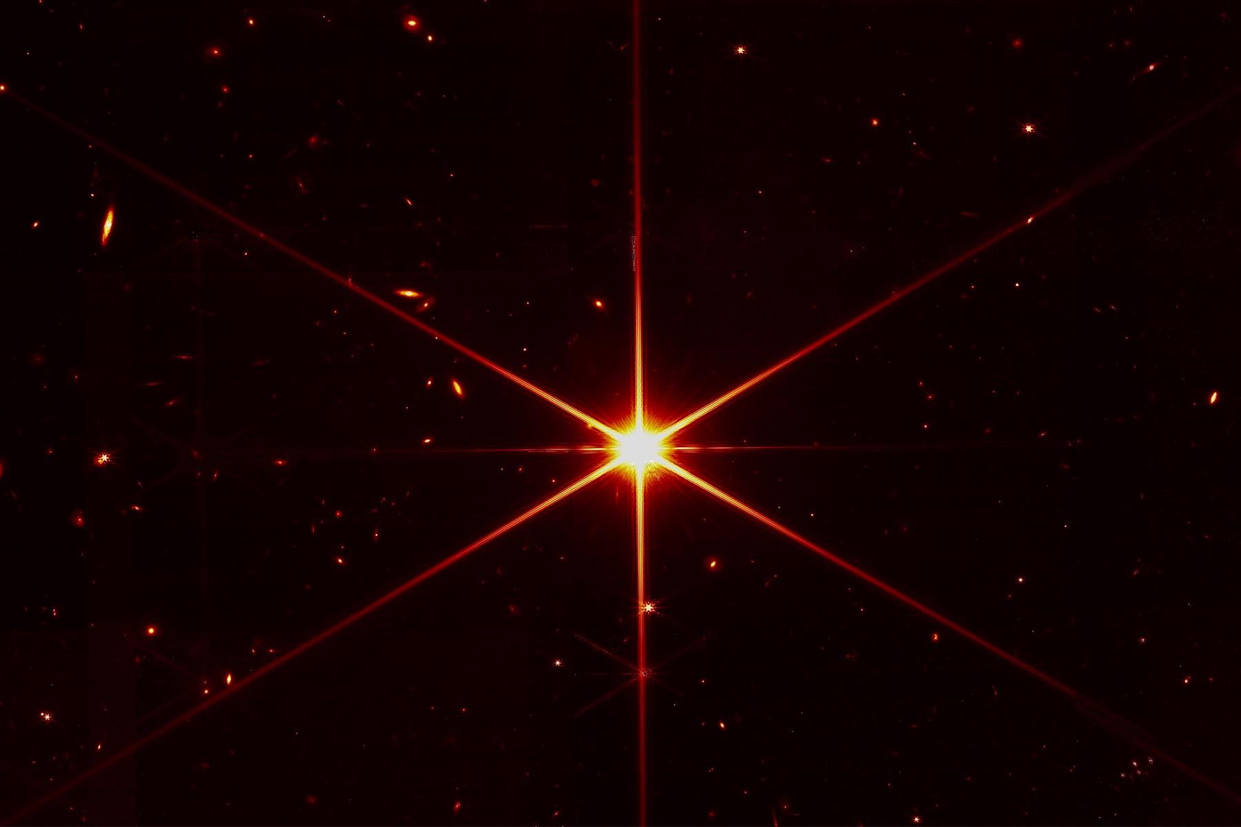 Aunque el propósito de esta imagen era enfocarse en la estrella brillante del centro para evaluar la alineación del telescopio, los sistemas ópticos de Webb y NIRCam son tan sensibles que se pueden ver las galaxias y estrellas que hay en el fondo. Foto: NASA