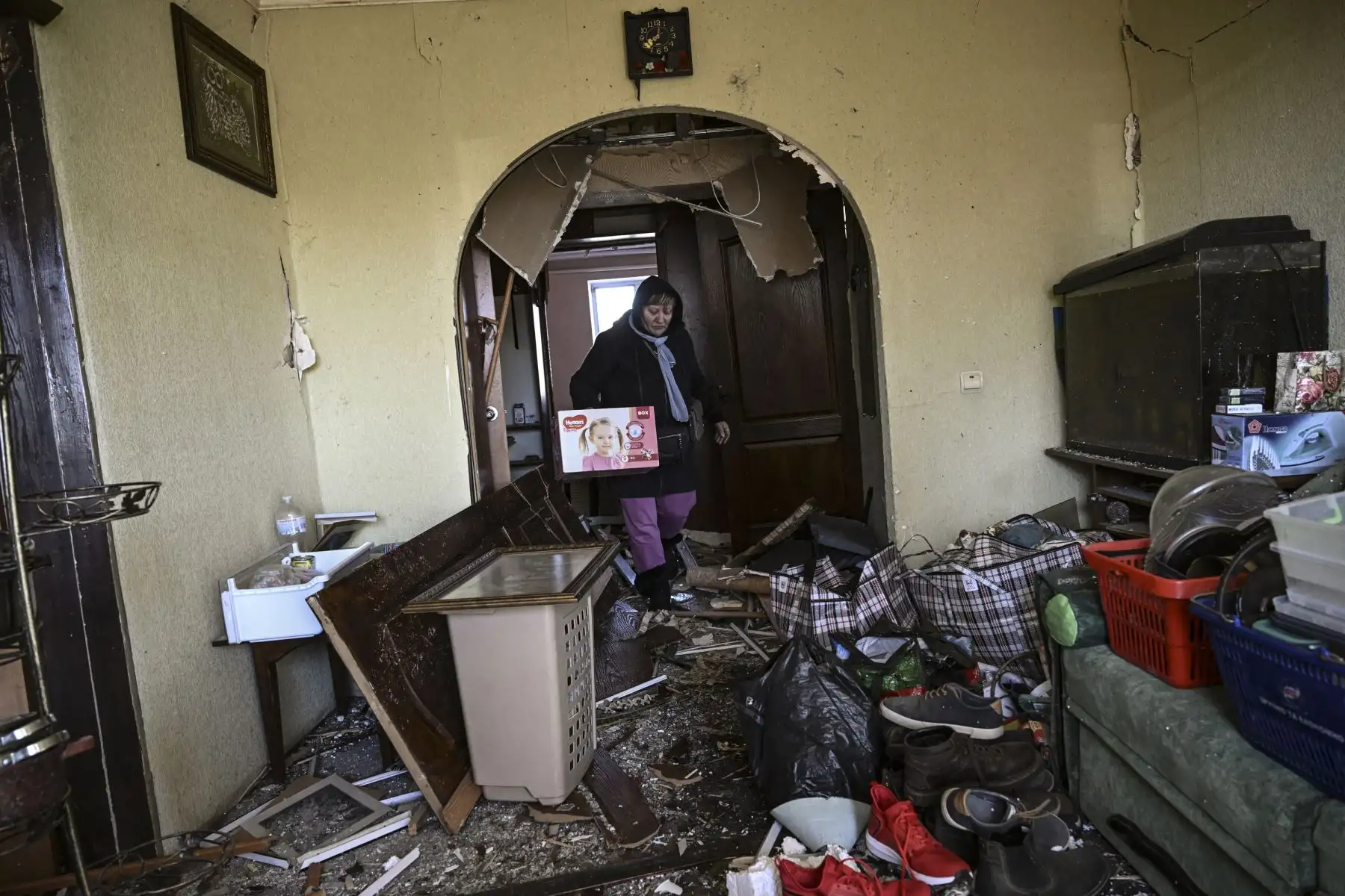 Una mujer recoge pertenencias de su apartamento destruido después de un bombardeo en Kiev. Foto: AFP