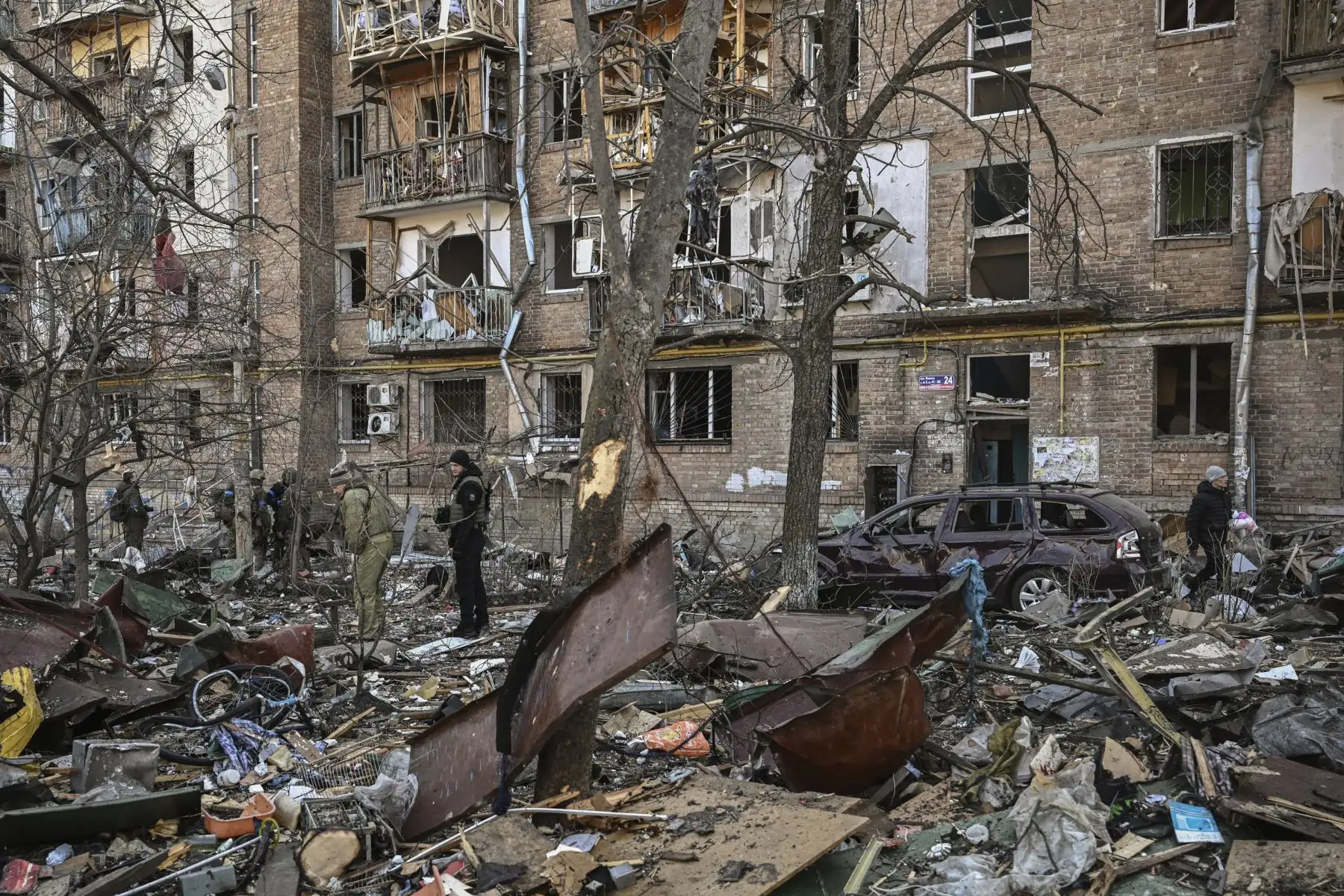 Militares ucranianos se paran en un edificio residencial de cinco pisos que se derrumbó parcialmente después de un bombardeo en Kiev. Foto: AFP