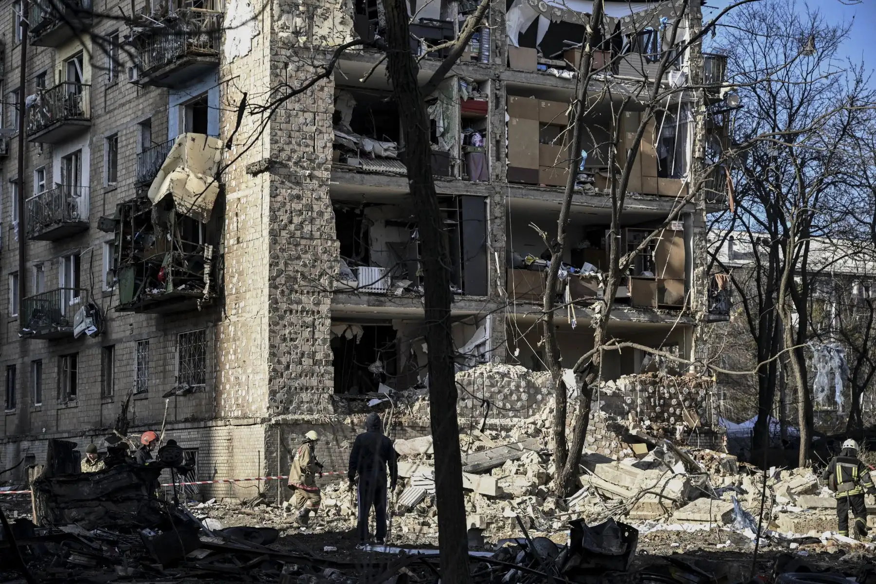 Militares ucranianos se paran en un edificio residencial de cinco pisos que se derrumbó parcialmente después de un bombardeo en Kiev. Foto: AFP