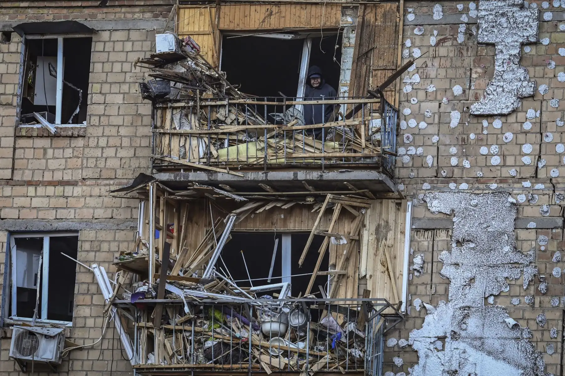 Un hombre se encuentra dentro de un apartamento destruido en una zona residencial después de un bombardeo en Kiev. Foto: AFP
