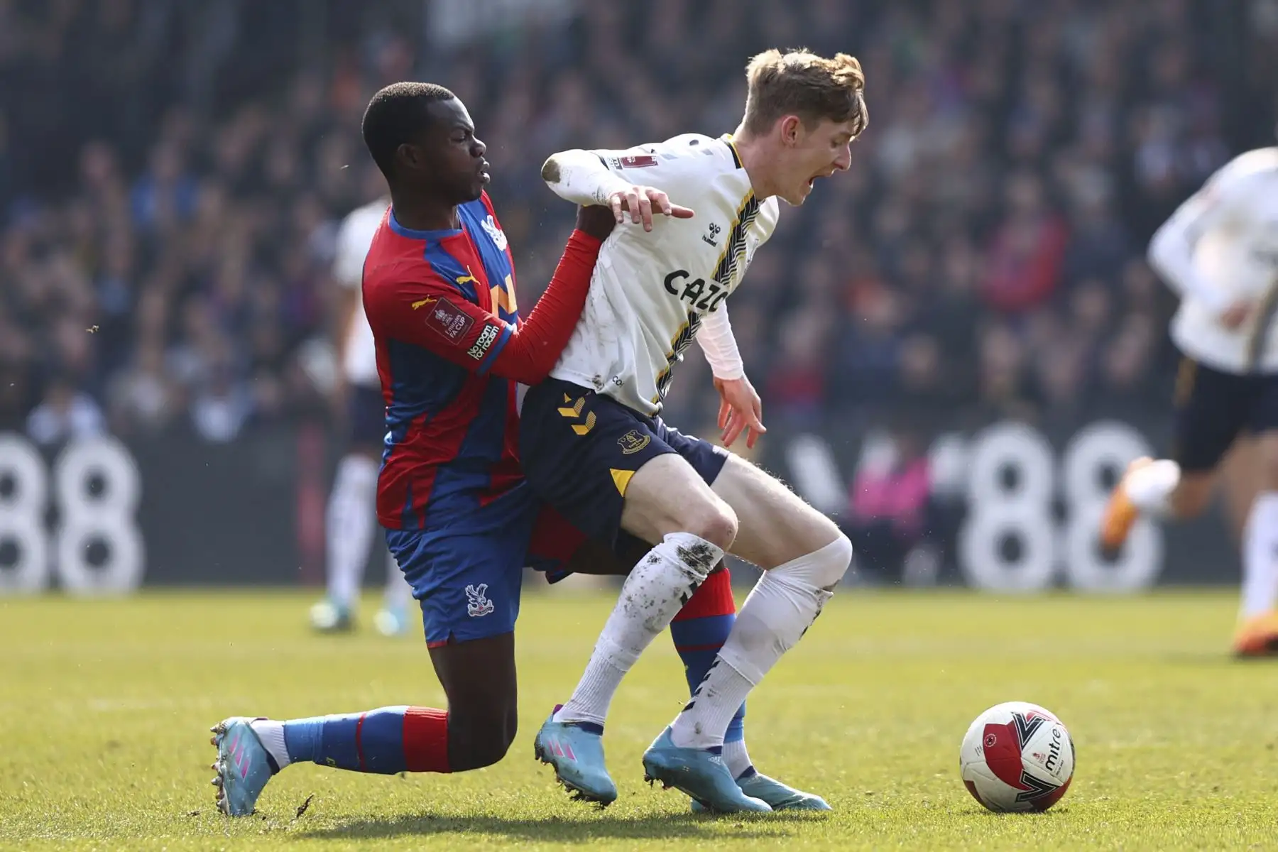 El defensor inglés del Crystal Palace, Tyrick Mitchell, compite con el delantero inglés del Everton, Anthony Gordon, durante el partidol de cuartos de final de la Copa FA. Foto: AFP