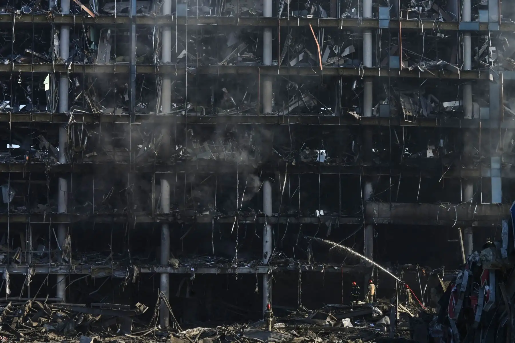 Bomberos trabajan en el lugar del destruido centro comercial Retroville tras el bombardeo ruso en Kiev. Foto: AFP
