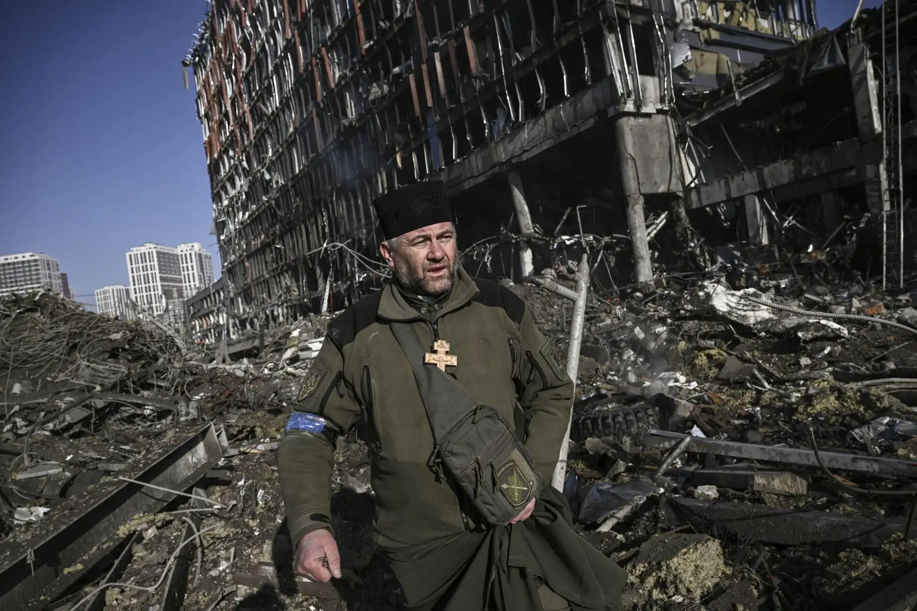El capellán del ejército de Ucrania Mikola Madenski camina a través de los escombros fuera del destruido centro comercial Retroville en un distrito residencial, después de un ataque ruso en la capital de Ucrania. Foto: AFP