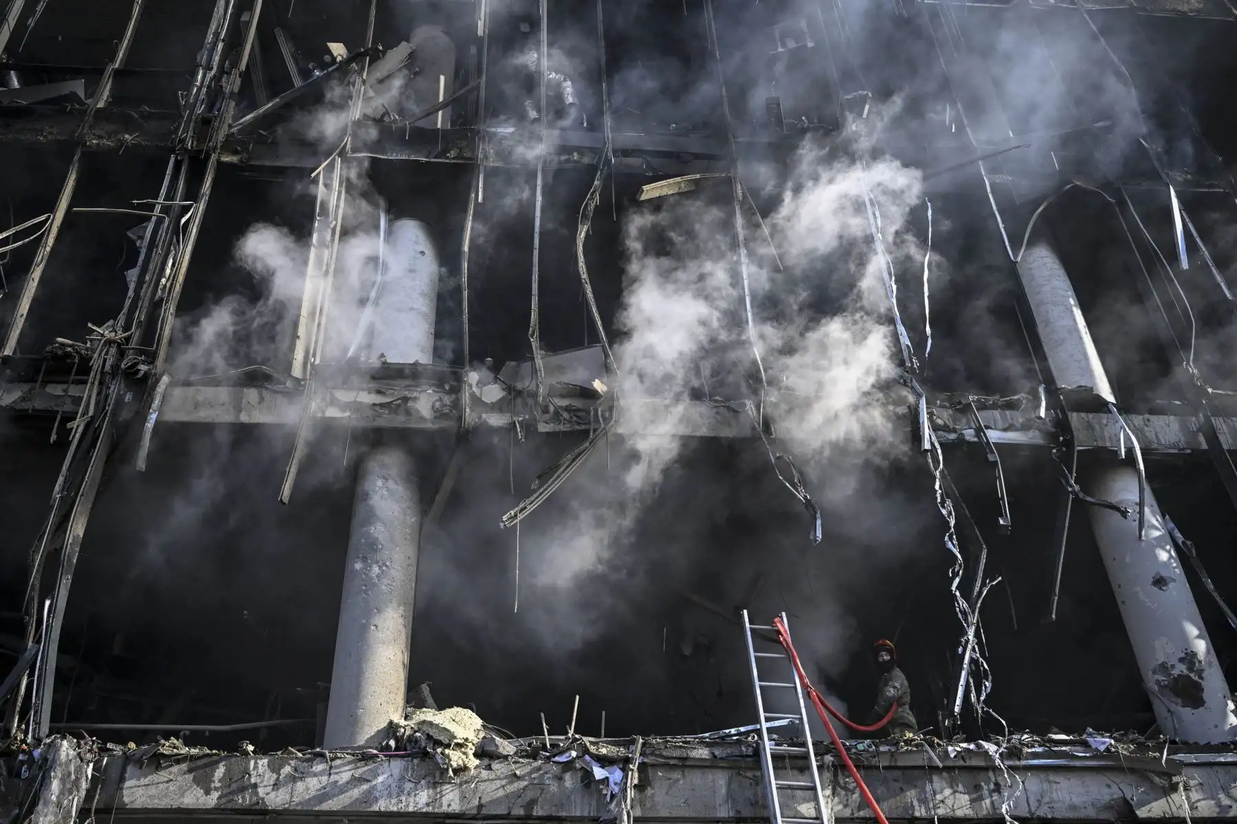 Bomberos dentro del centro comercial Retroville después de un ataque ruso en el noroeste de la capital, Kiev. Foto: AFP
