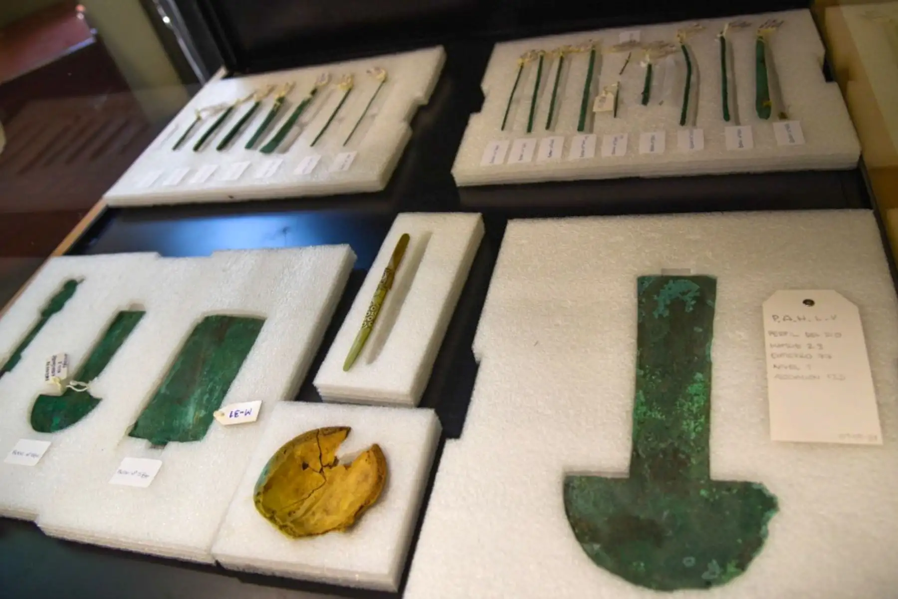 La plancheta de metal junto a un tumi similar al del Colegio Médico del Perú. “Este símbolo hace más de mil años era un elemento que estaba ligado a los instrumentos quirúrgicos. Al lado estaban dos huesos frontales, uno de un adulto y otro de un joven. Se trata de frontales humanos modificados y cuidadosamente cortados bajo un criterio de trepanación. Eso dedujo que fuera la evidencia que servirían como cuchillos especiales para cirugía”. Foto: Museo Nacional de Sicán