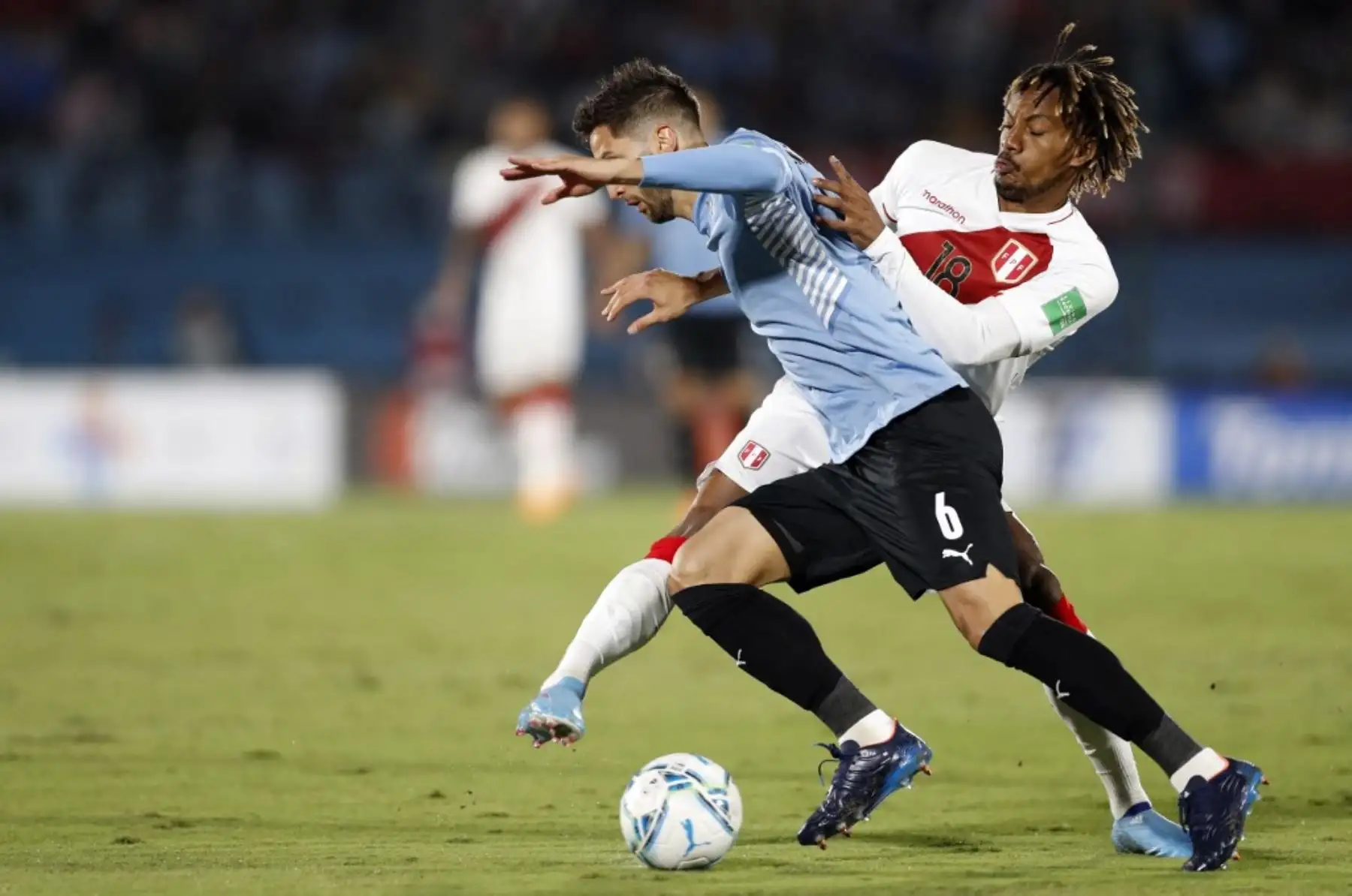Rodrigo Bentancur de Uruguay y André Carrillo de Perú compiten por el balón durante su partido de fútbol de clasificación sudamericana para la Copa Mundial de la FIFA Qatar 2022 en el Estadio Centenario de Montevideo. Foto: AFP