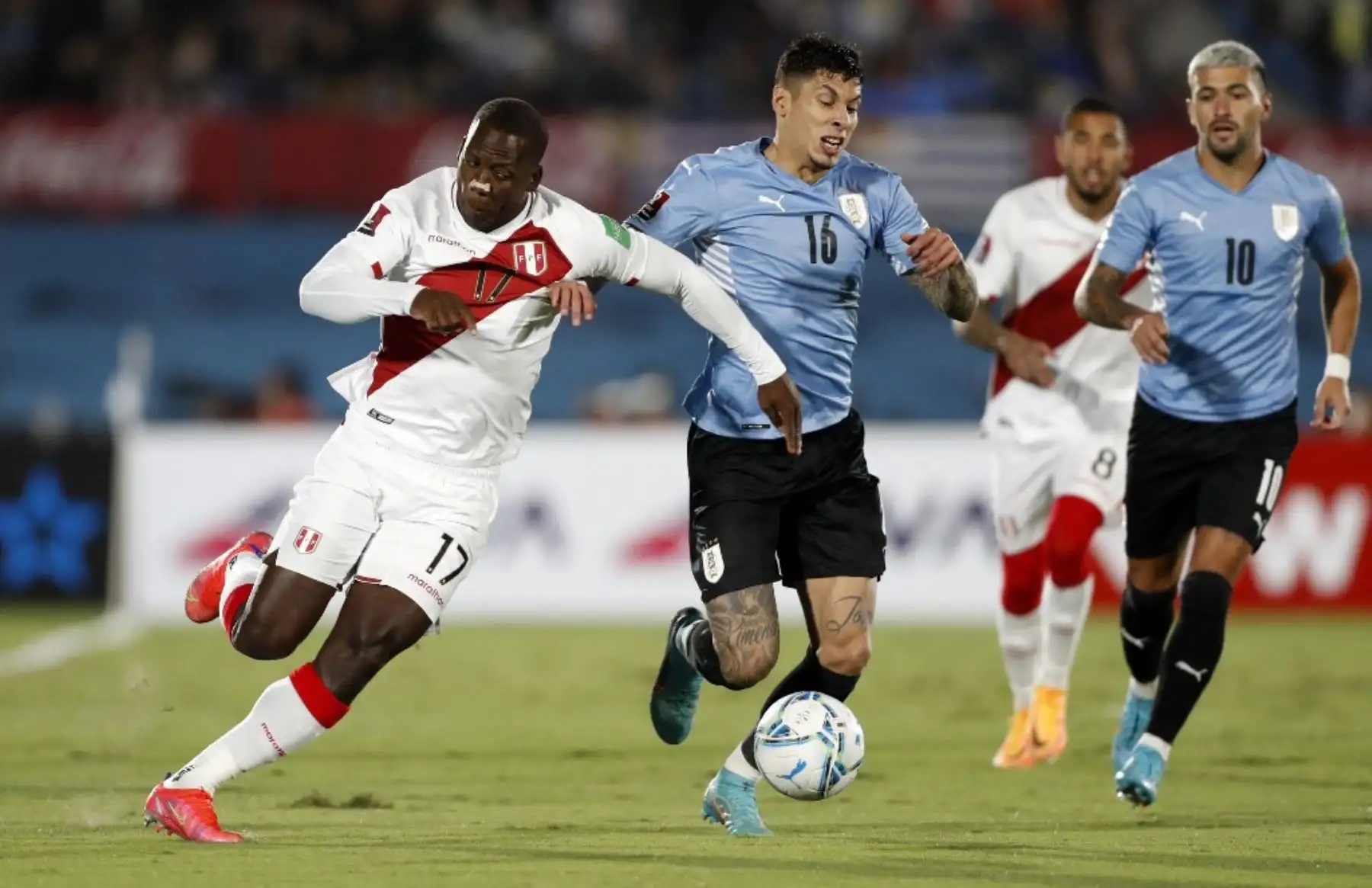 Luis Advincula de Perú y Mathias Olivera de Uruguay compiten por el balón durante su partido de clasificación sudamericano para la Copa Mundial de la FIFA Qatar 2022 en el Estadio Centenario de Montevideo el 24 de marzo de 2022. Foto: AFP