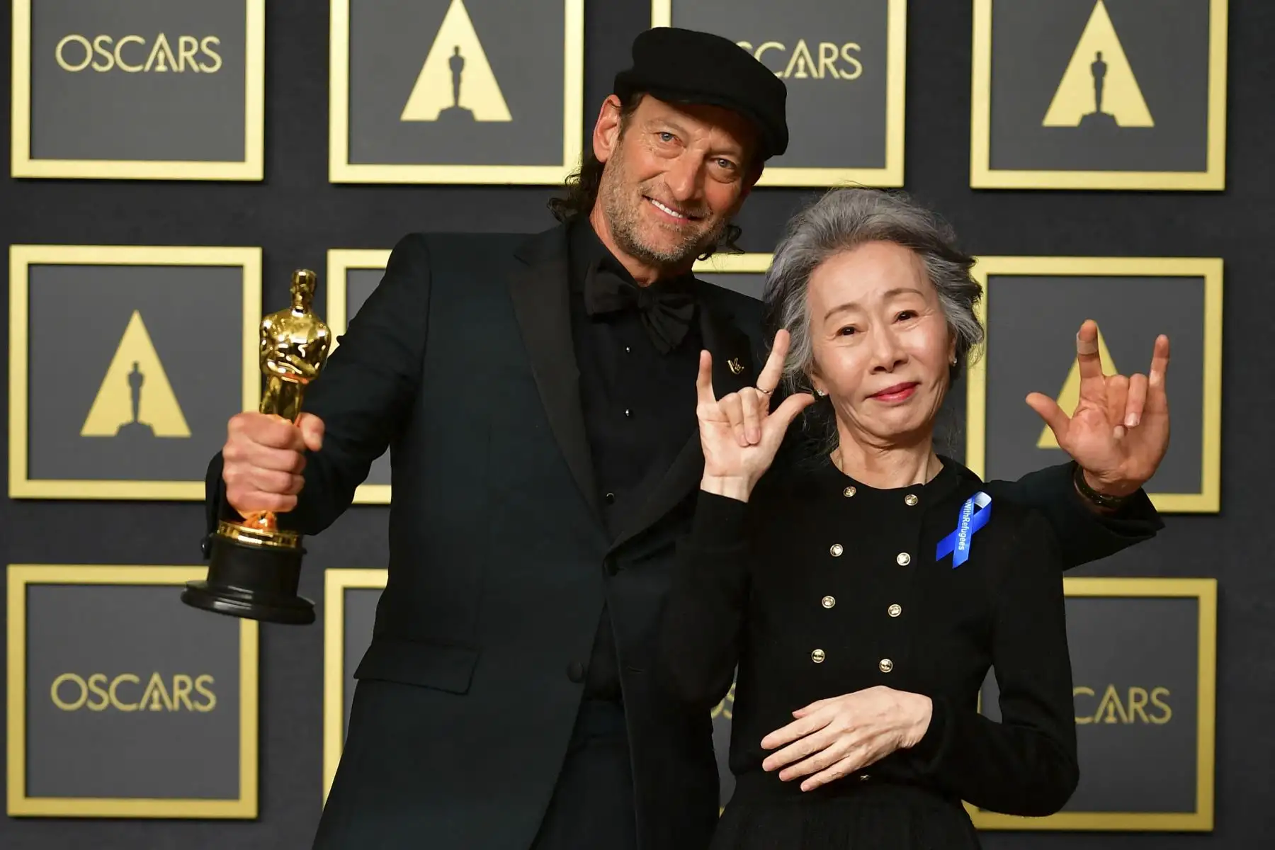 El actor estadounidense Troy Kotsur (izquierda) muestra su premio al mejor actor de reparto por "CODA" junto a la actriz surcoreana Youn Yuh-jung en la sala de prensa durante la 94ª entrega de los Oscar en el Dolby Theatre de Hollywood. Foto: AFP