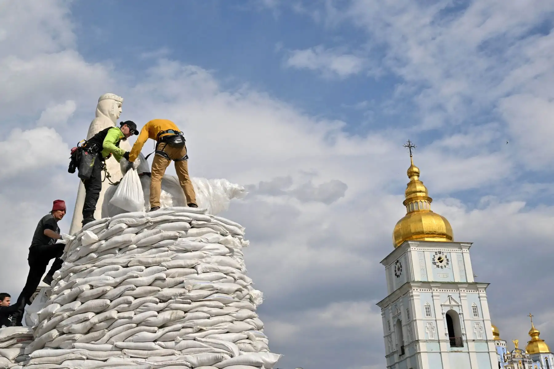Voluntarios ensamblan sacos de arena para cubrir y proteger el Monumento a la Princesa Olga, San Andrés Apóstol y los educadores Cirilo y Metodio en Kiev. Foto: AFP