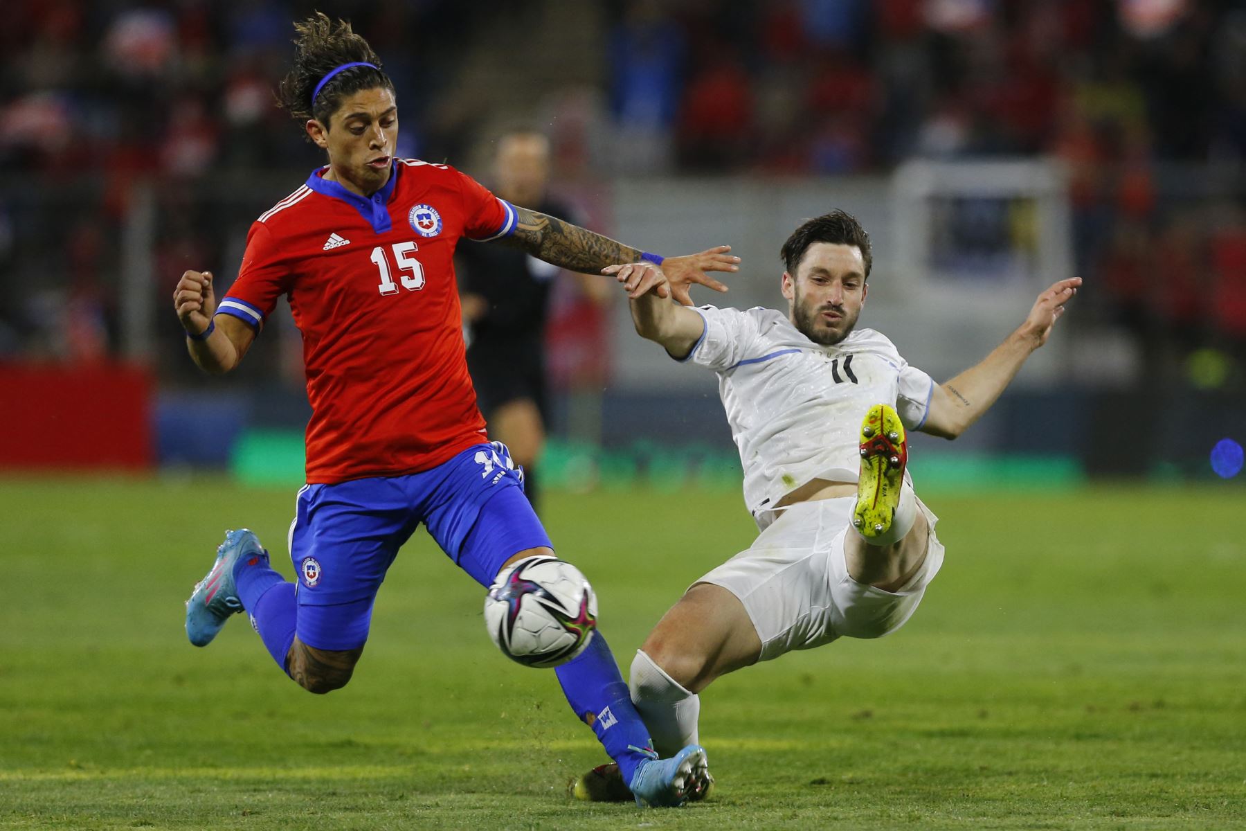 El chileno Joaquín Montecinos (L) y el uruguayo Matías Vina compiten por el balón durante su partido de fútbol clasificatorio sudamericano para la Copa Mundial de la FIFA Qatar 2022 en el estadio San Carlos de Apoquindo en Santiago. Foto: AFP