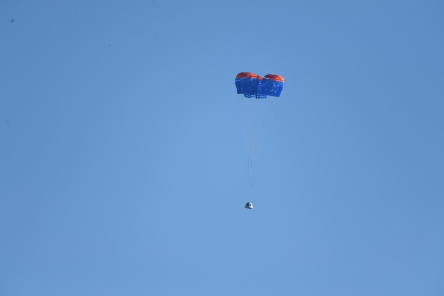 Una cápsula de la tripulación de Blue Origin New Shepard despliega sus paracaídas cuando aterriza en el oeste de Texas al norte de Van Horn. Foto: AFP
