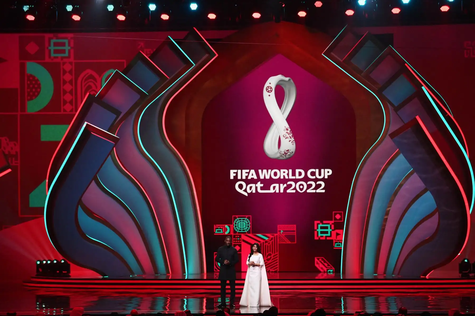 El actor inglés Idris Elba y el periodista deportivo británico-bangladeshi Reshmin Chowdhury caminan en el escenario durante el sorteo de la Copa Mundial 2022 en Catar. Foto: AFP