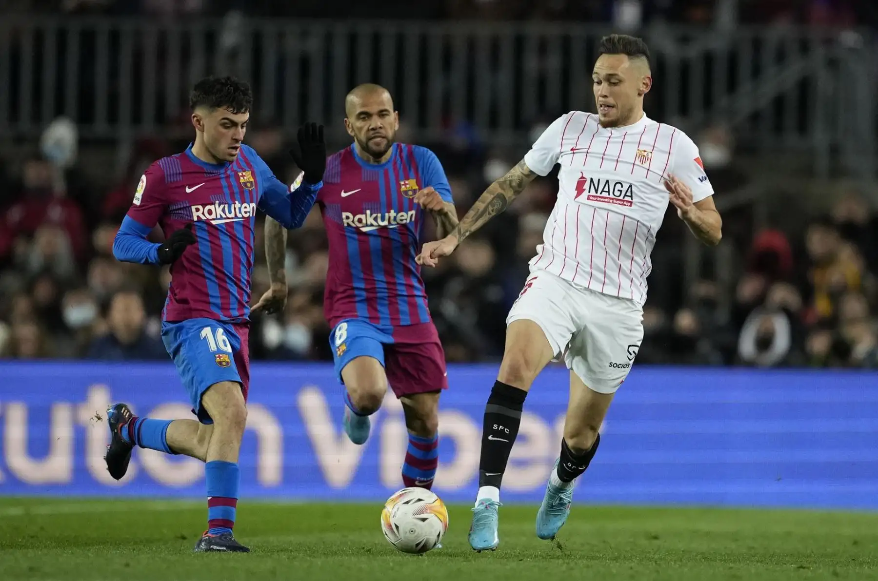 El centrocampista del FC Barcelona Pedro González "Pedri" (i) lucha con el argentino Lucas Ocampos, del Sevilla FC, durante el encuentro de la jornada 30 de Liga en Primera División que FC Barcelona y Sevilla FC juegan hoy domingo en el Camp Nou, en Barcelona. EFE/Toni Albir