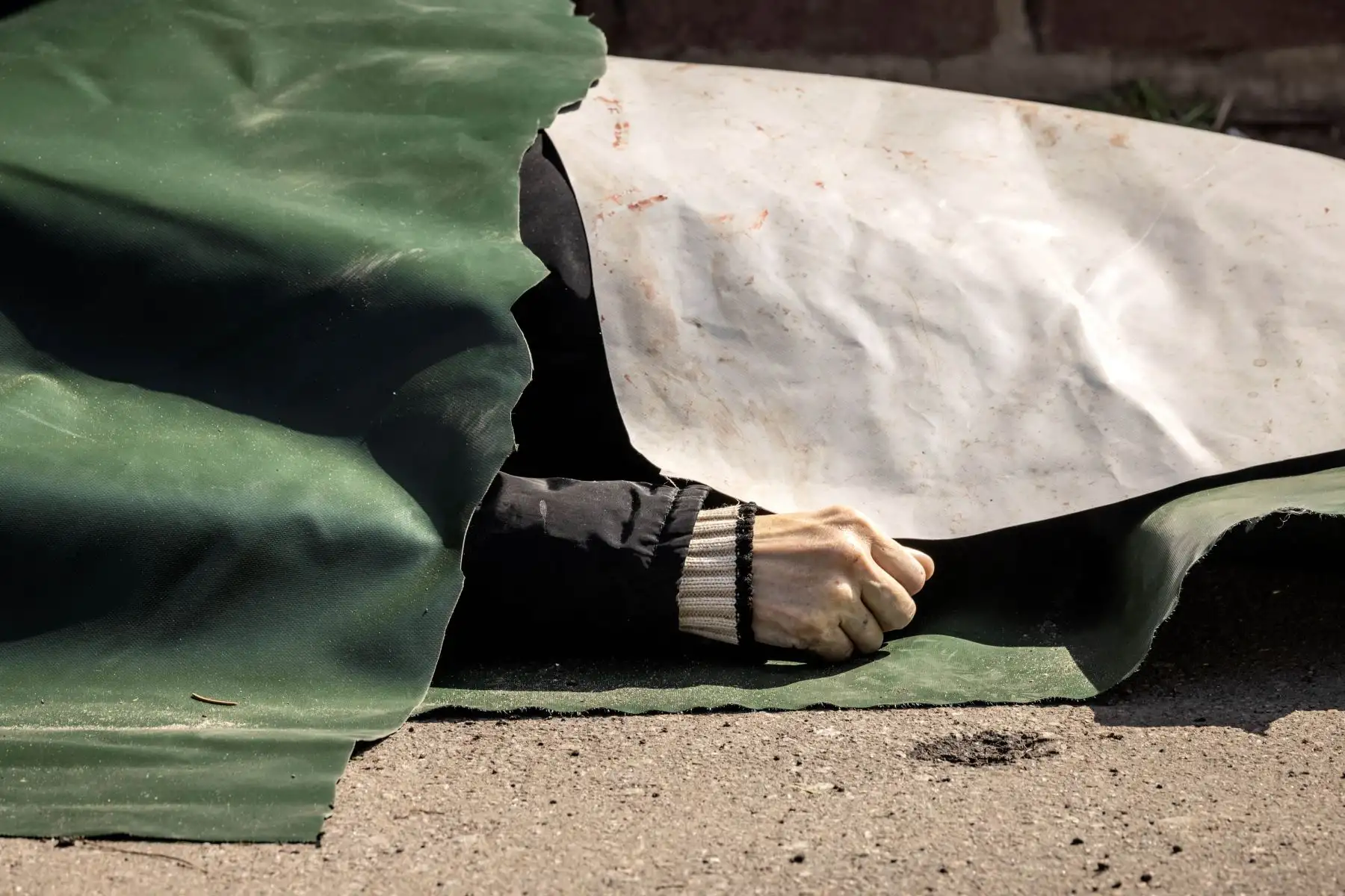 Un cuerpo yace en el suelo cubierto con láminas de plástico después de que un ataque con cohetes mató al menos a 35 personas en una estación de tren. Foto: AFP