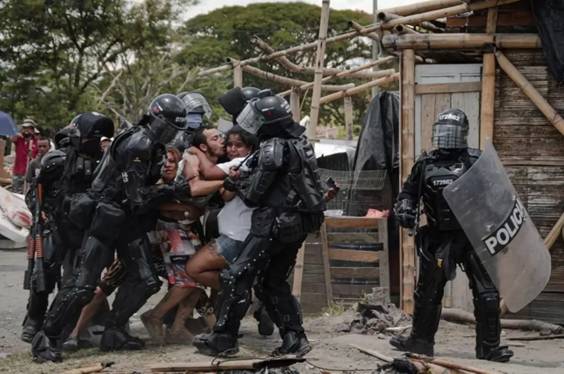 Agentes policiales arrestan a un hombre mientras su esposa y su familia resisten, durante los desalojos de personas del asentamiento San Isidro, en Puerto Caldas, Risaralda, Colombia, el 6 de marzo de 2021.
Foto: Vladimir Encina / WPP