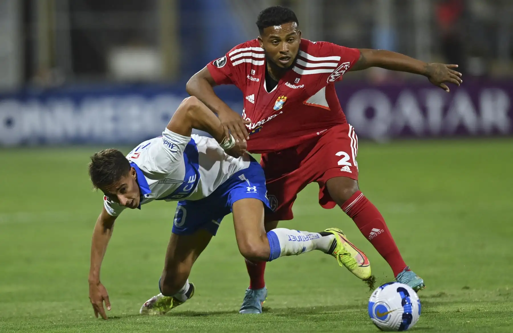 Diego Valencia (L) de la Universidad Católica de Chile y Sporting Cristal Johan Madrid de Perú disputan el balón durante el partido de ida de la fase de grupos de la Copa Libertadores, en el San Carlos de Apoquindo en Santiago
Foto: ANDINA/AFP