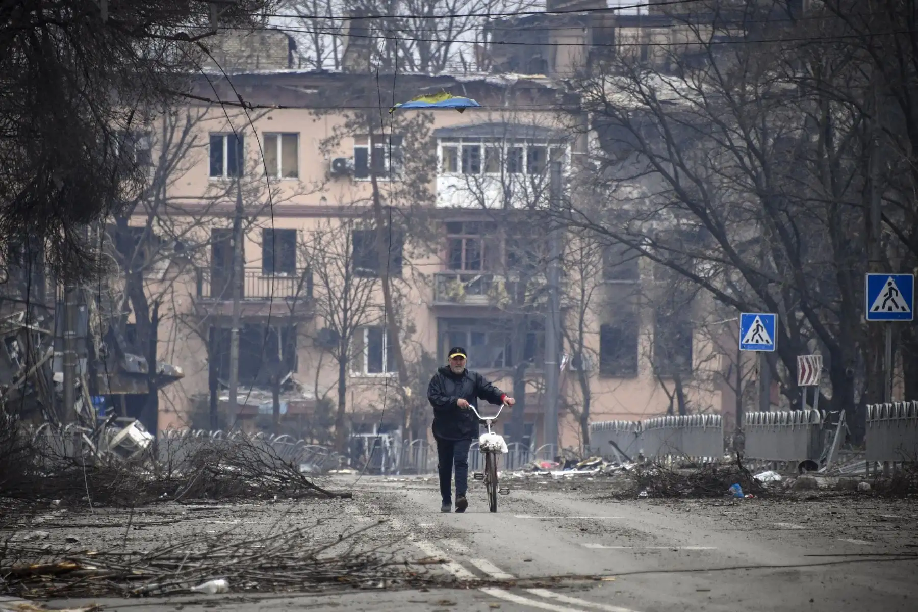 Un hombre camina con una bicicleta en el centro de Mariupol, mientras las tropas rusas intensifican una campaña para tomar la ciudad portuaria estratégica, parte de un ataque masivo anticipado en el este de Ucrania. Foto. AFP