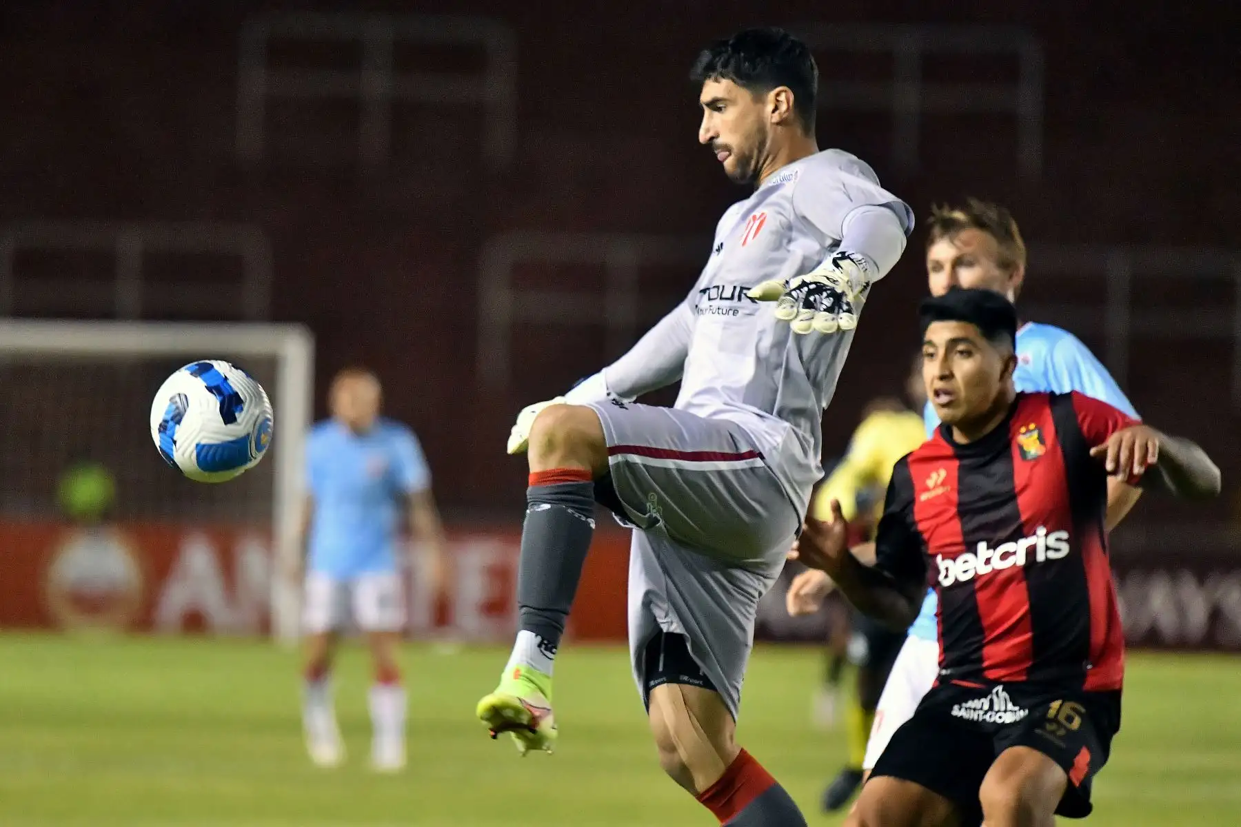 El portero de River Plate de Uruguay Salvador Ichazo y Melgar Luis Iberico de Perú compiten por el balón durante su partido de fútbol de ida de la fase de grupos de la Copa Sudamericana, en el Estadio Monumental de Arequipa. Foto: AFP