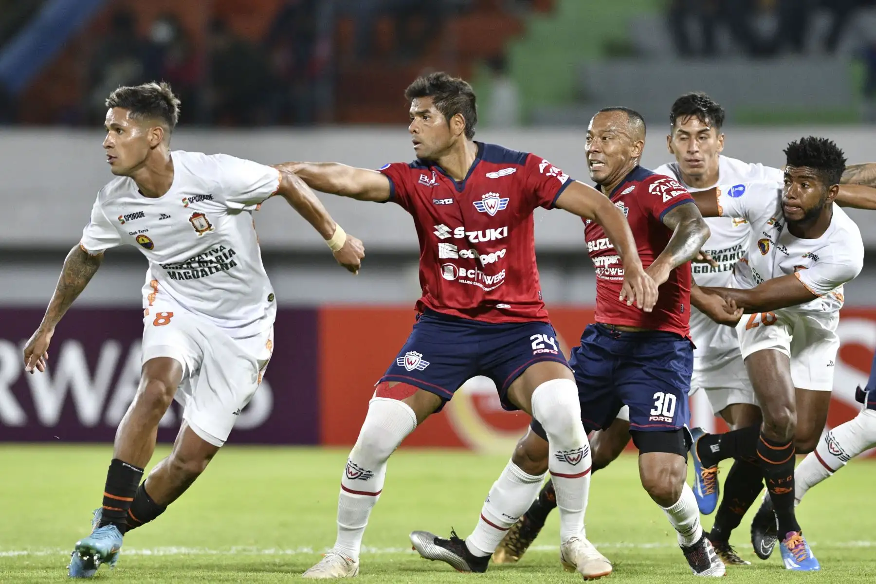 Eric Barrios y Jorge Toledo de Ayacucho compiten con el colombiano Humberto Osorio  y Edemir Rodríguez (centro) de Jorge Wilstermann de Bolivia durante el partido de ida de la fase de grupos de la Copa Sudamericana, en el estadio Félix Capriles de Cochabamba, Bolivia. Foto: AFP