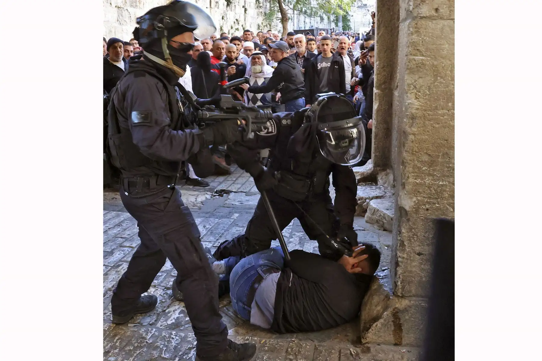 Fuerzas de seguridad israelíes inmovilizan a un hombre palestino en la entrada del complejo de la mezquita de al-Aqsa en Jerusalén. Foto: AFP