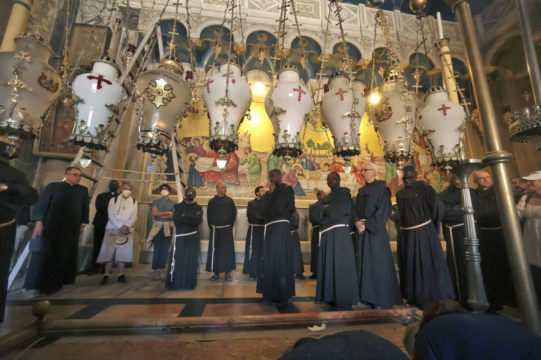 Frailes franciscanos se unen a los creyentes en oración en la Iglesia del Santo Sepulcro, durante la procesión del Viernes Santo en la Ciudad Vieja de Jerusalén. Foto: AFP
