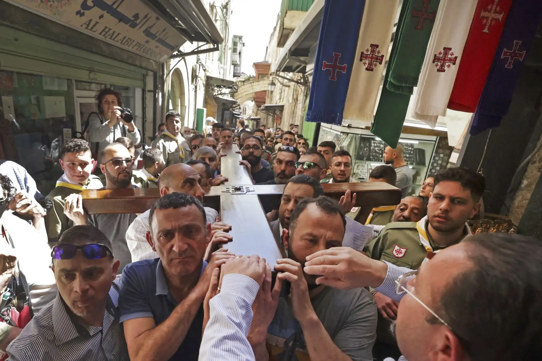 Fieles cristianos llevan una cruz de madera a lo largo de la Vía Dolorosa , durante la procesión del Viernes Santo en la Ciudad Vieja de Jerusalén. Foto: AFP