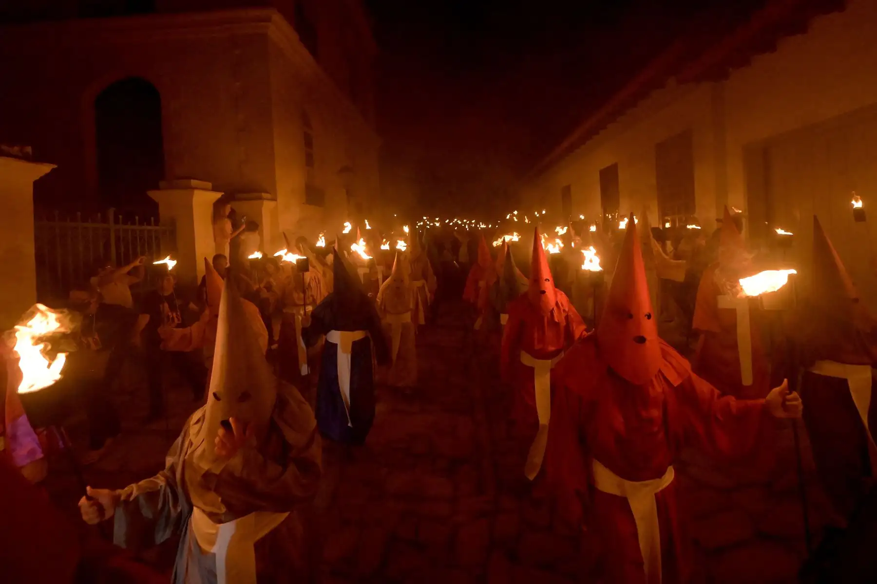 Fieles católicos encapuchados que representan a los soldados romanos, conocidos como "Farricocos", llevan antorchas encendidas durante la procesión anual de Semana Santa de Fogareu en Goias, Brasil. Foto: AFP