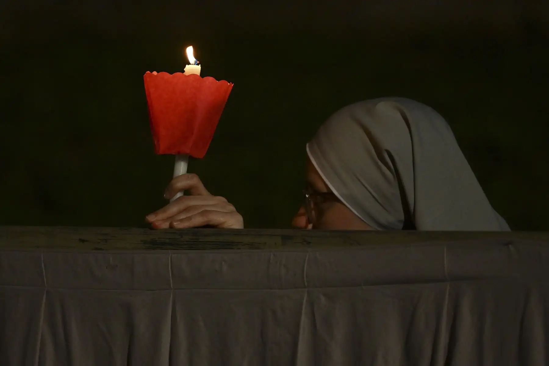 Una monja sostiene una vela junto al monumento del Coliseo durante el Vía Crucis presidido por el Papa el Viernes Santo, 15 de abril de 2022 en Roma.
Foto: ANDINA/AFP
