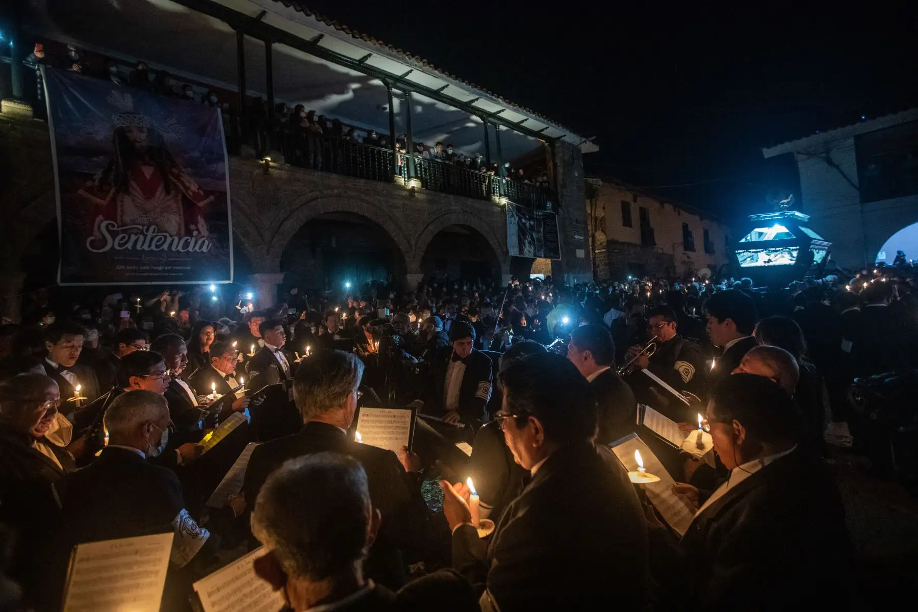 El coro y orquesta de los Caballeros Cantores del Santo Sepulcro, de riguroso luto, acompañan la multitudinaria procesión del Señor del Santo Sepulcro, en la plaza de armas de Huamanga, Ayacucho. El perímetro quedó en penumbras, solo iluminado con velas.
Foto: ANDINA/Carla Patiño