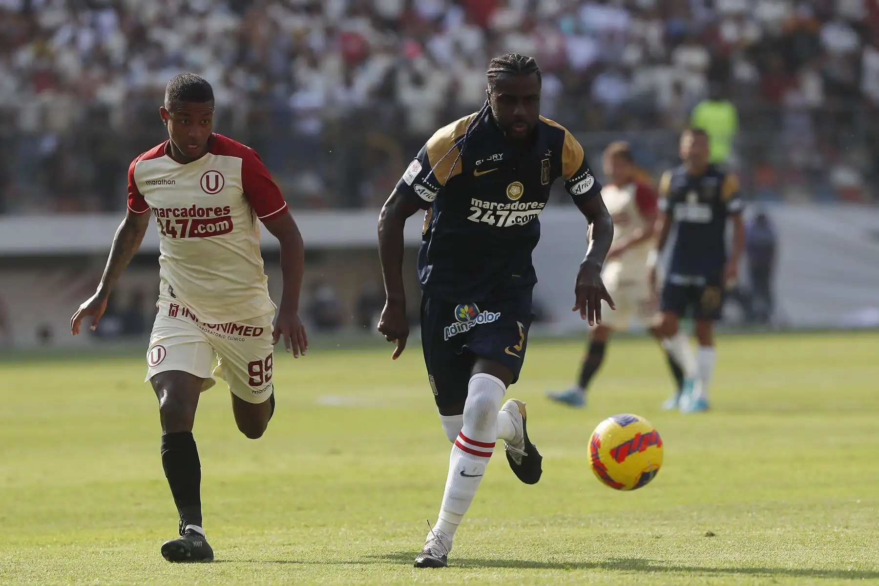 Cristian Ramos de Alianza Lima disputa el balón ante el jugador de   Universitario de Deportes en el clásico de fútbol peruano por la jornada 10 de la Liga 1, Estadio Monumental de Ate. 
Foto: ANDINA/Renato Pajuelo