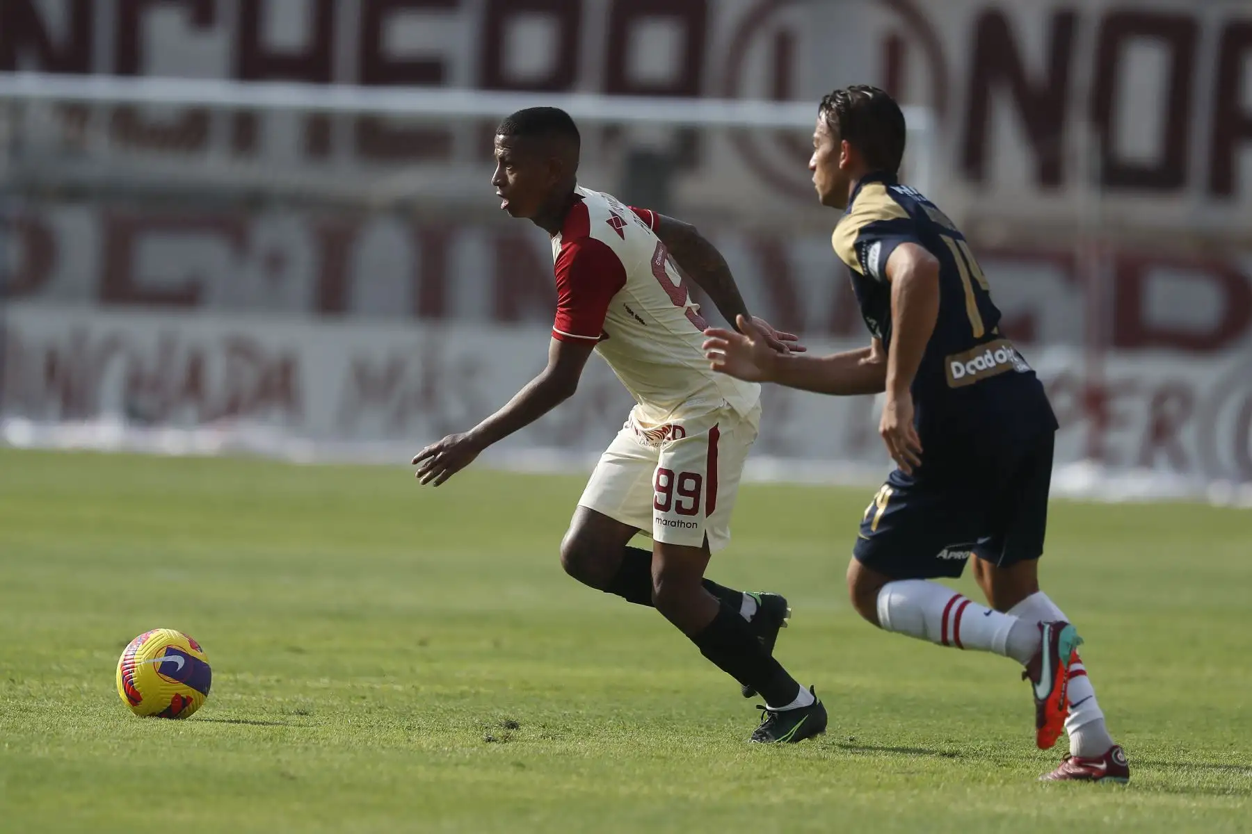 Andy Polo de Universitario de Deportes disputa el balón ante el jugador de Alianza Lima, Cristian Benavente en el clásico de fútbol peruano por la jornada 10 de la Liga 1 en el Estadio Monumental de Ate. 
Foto: ANDINA/Renato Pajuelo