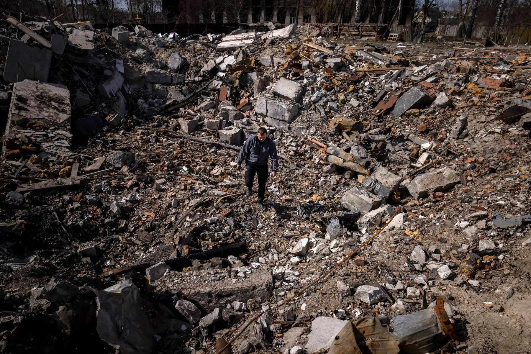 Un policía camina entre los escombros de las casas destruidas en la aldea de Bohdanivka, al noreste de Kiev. Foto: AFP