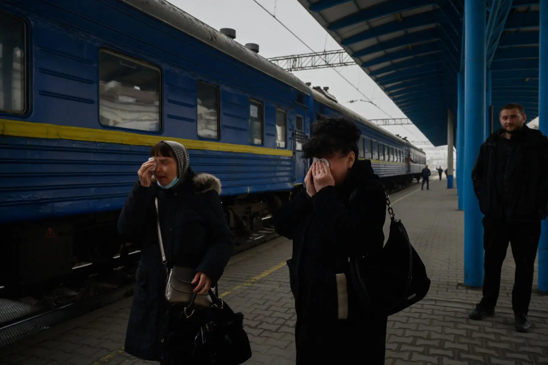 Mujeres lloran cuando un tren para desplazados internos se prepara para salir de la estación principal de trenes en Zaporijia, en el sur de Ucrania. Foto: AFP