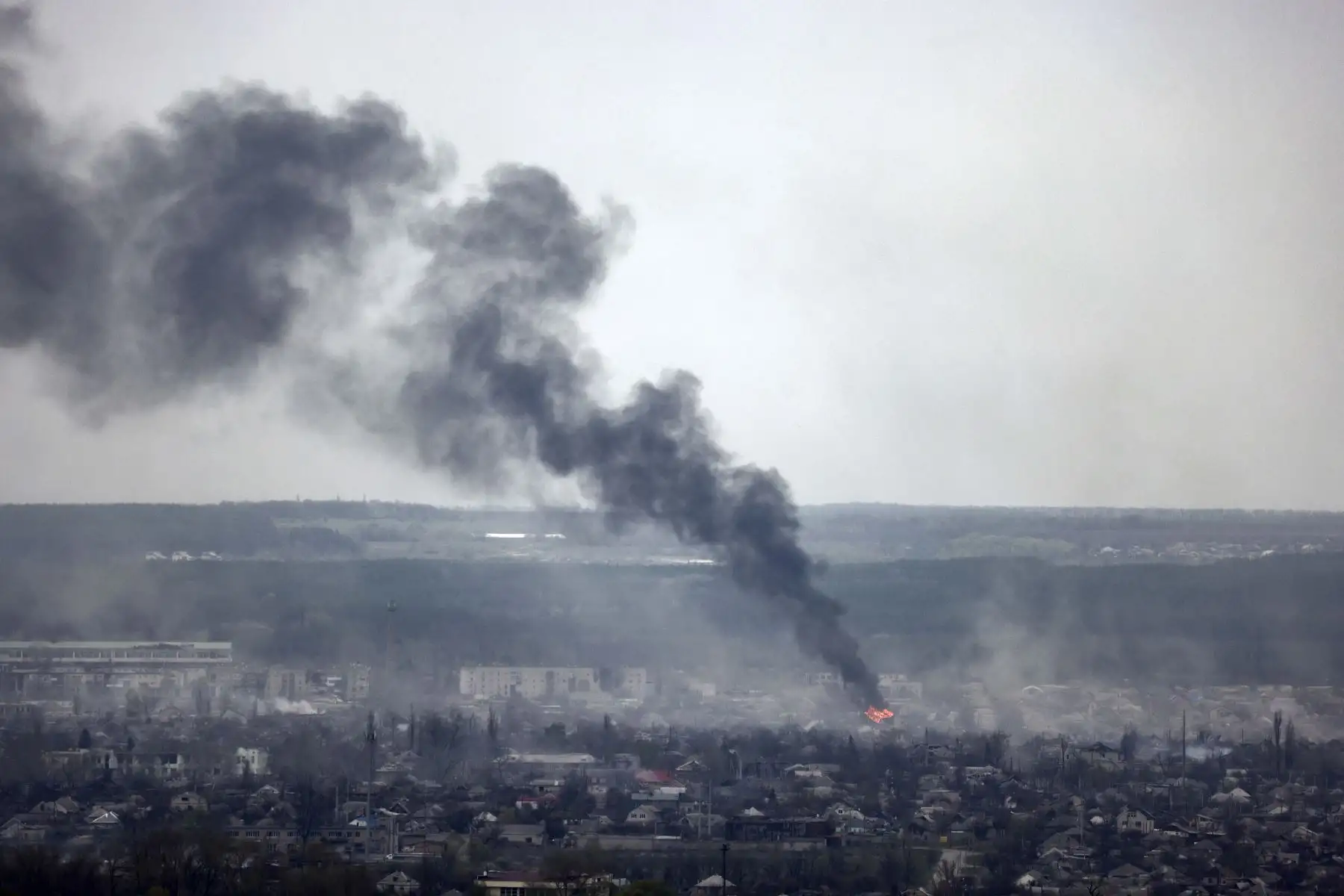 Una fotografía tomada de la aldea de Novodruzhesk muestra humo oscuro que se eleva en la ciudad de Rubizhne, en el día 54 de la invasión rusa de Ucrania. Foto: AFP