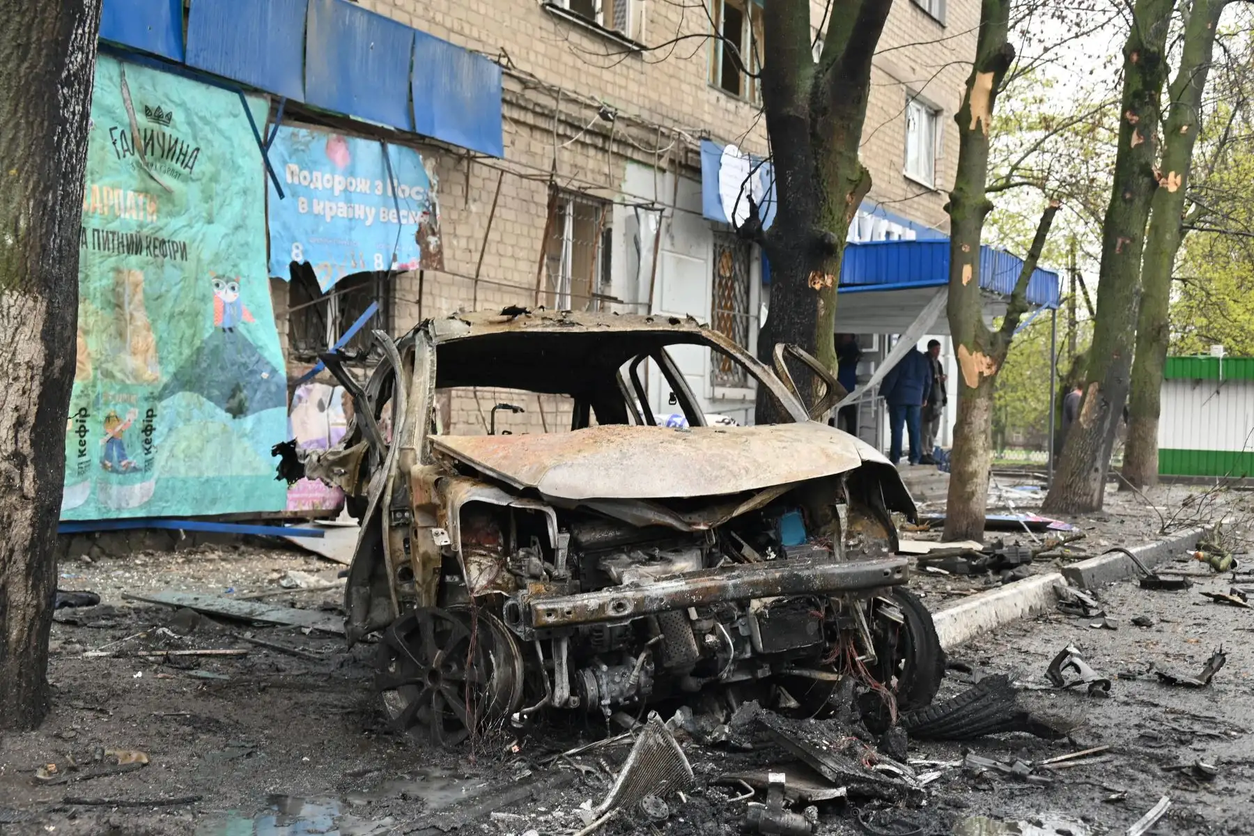 Escombros de un automóvil destruido por una explosión cerca de una tienda de comestibles en Kharkiv, Ucrania. Foto: AFP