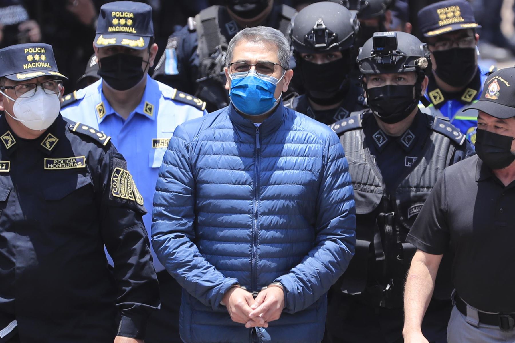 Policías custodian al expresidente hondureño Juan Orlando Hernández (c) rumbo a su extradición, hoy, en la sede de la Dirección Nacional Fuerzas Especiales, en Tegucigalpa (Honduras). Foto: EFE