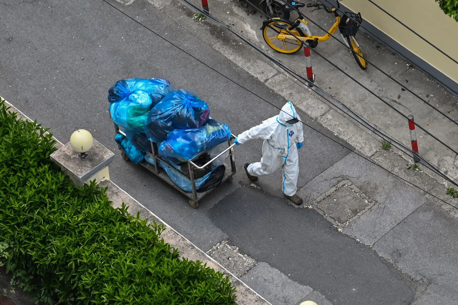 Un trabajador con equipo de protección personal (EPP) limpia las calles durante un bloqueo de coronavirus Covid-19 en Shanghai. Foto: AFP