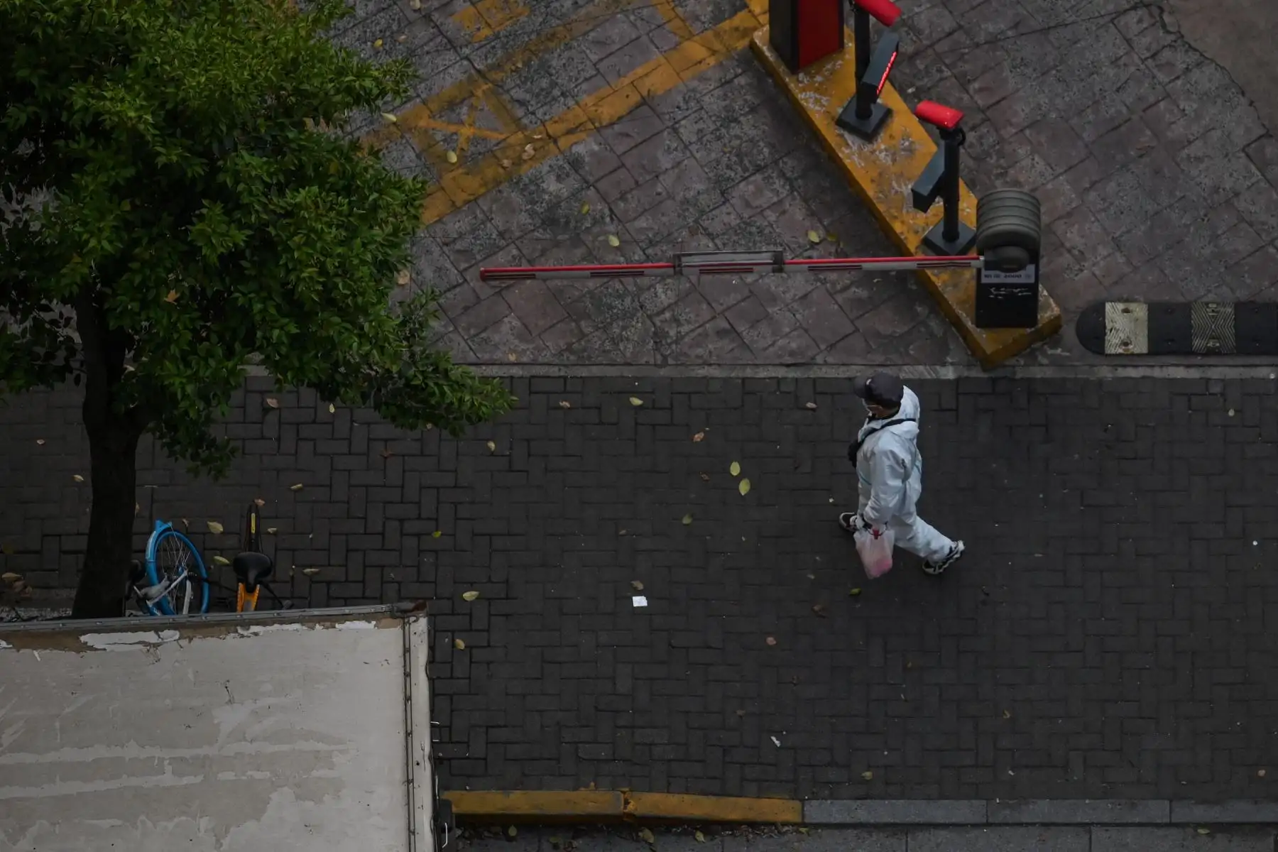 Un trabajador con equipo de protección personal (EPP) limpia las calles durante un bloqueo de coronavirus Covid-19 en Shanghai. Foto: AFP