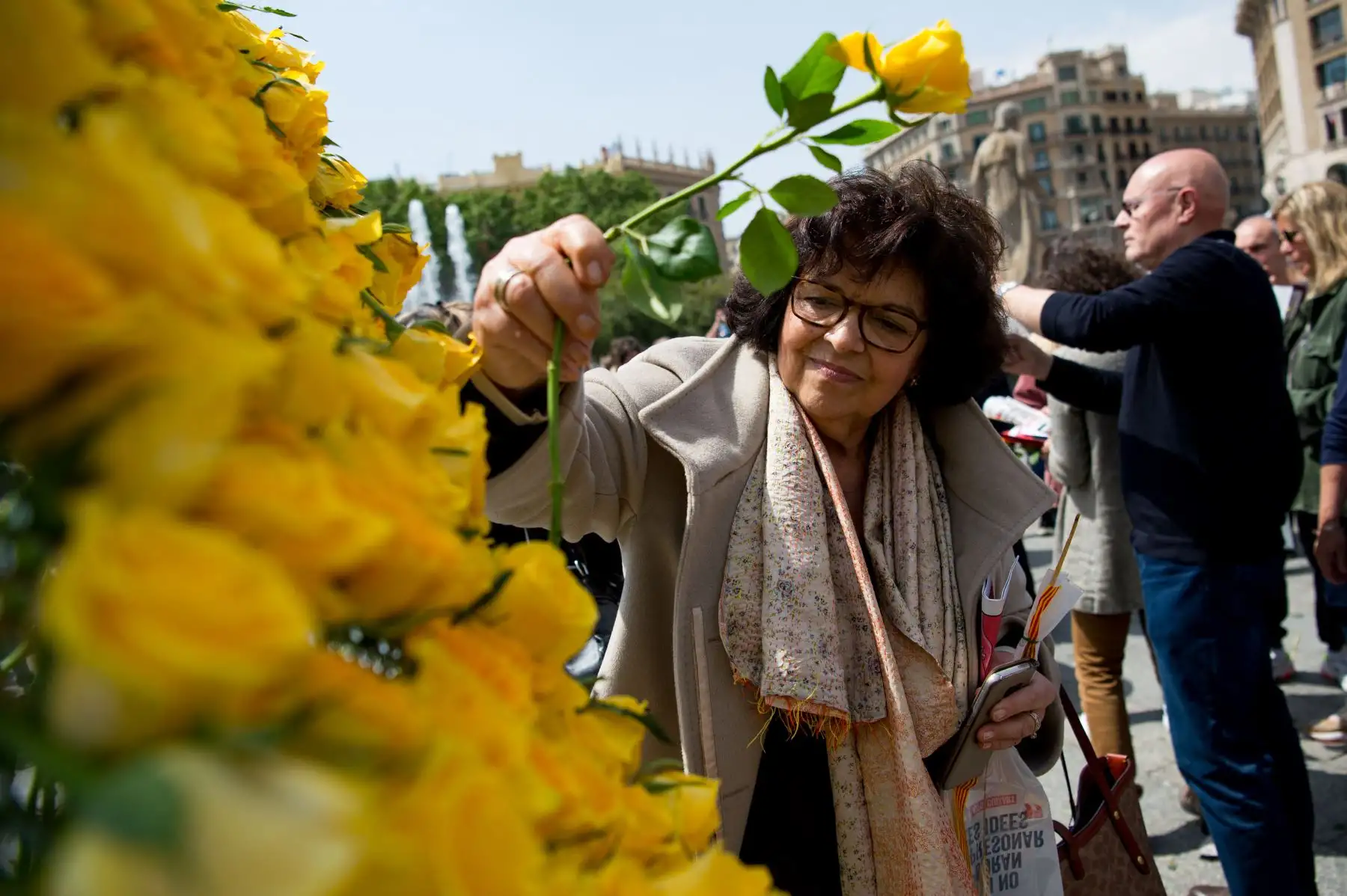 Una mujer coloca una rosa amarilla en letras que dicen "Libertad" durante las festividades de Sant Jordi que marcan el día de San Jorge.
Foto: AFP