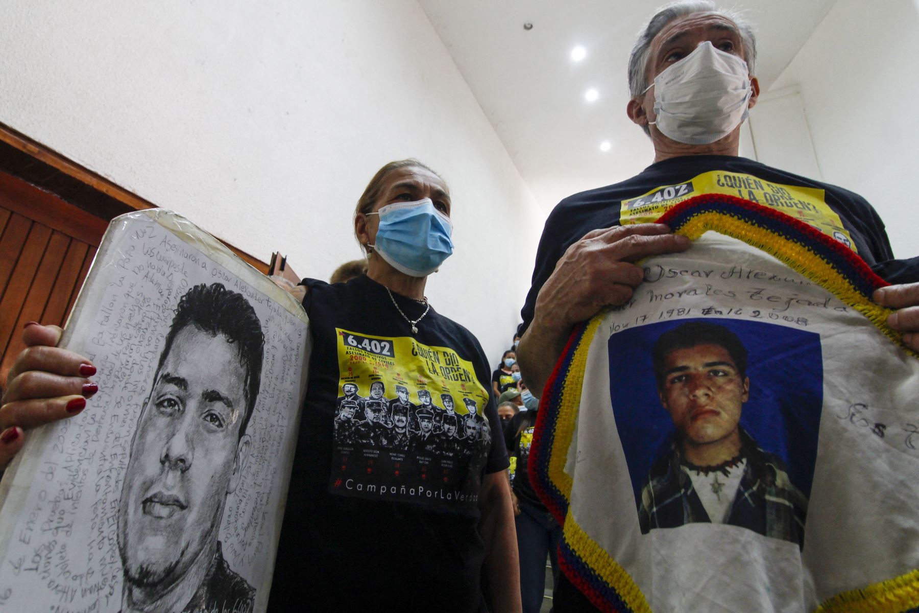 Familiares de una víctima sostienen carteles con su retrato durante una audiencia organizada por la Jurisdicción Especial para la Paz en Ocaña, Colombia.
Foto. AFP