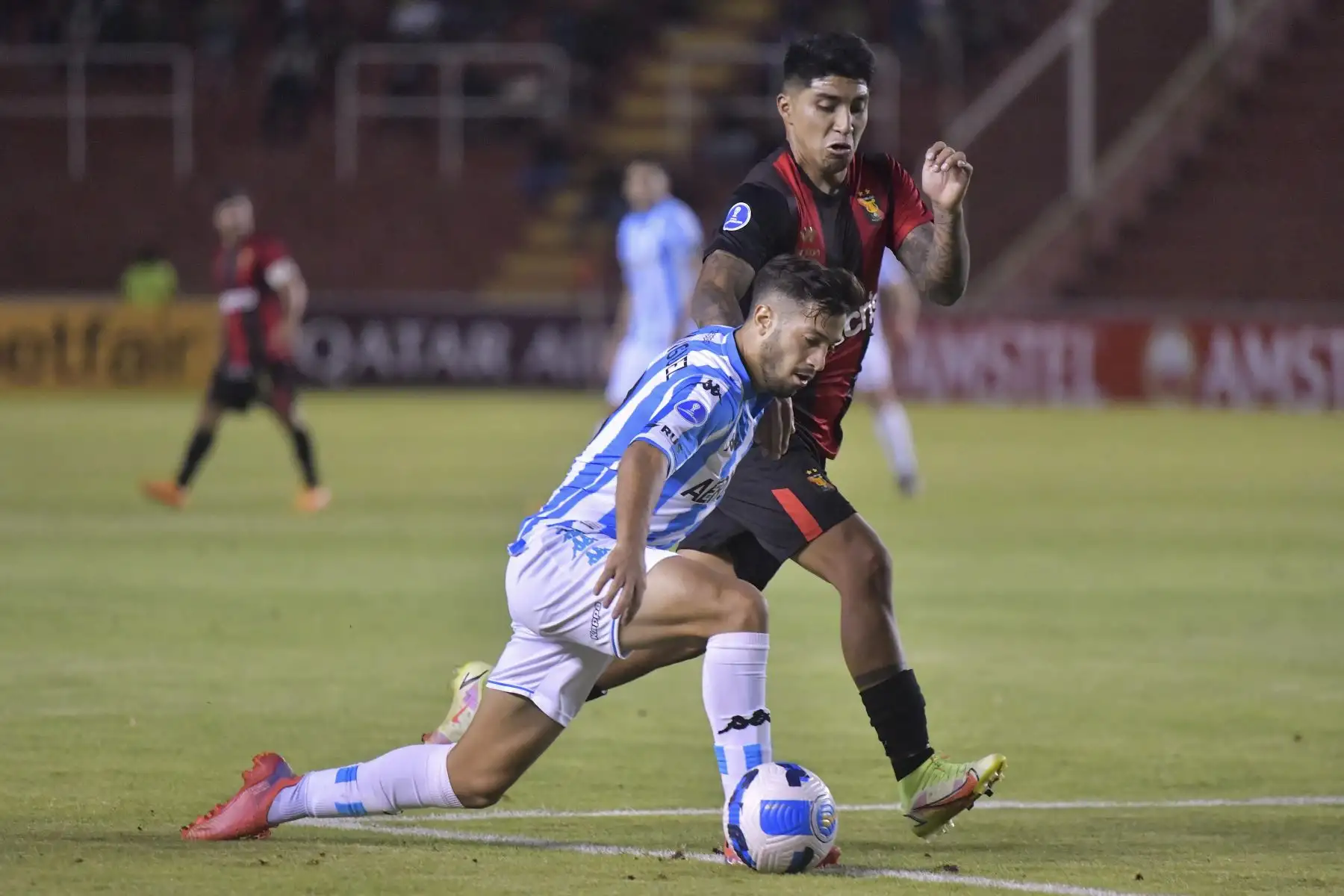 Fabricio Domínguez de Racing de Argentina y Luis Iberico de Melgar, compiten por el balón durante su partido de fútbol de la fase de grupos de la Copa Sudamericana en el estadio Monumental de la UNSA en Arequipa. Foto: AFP
