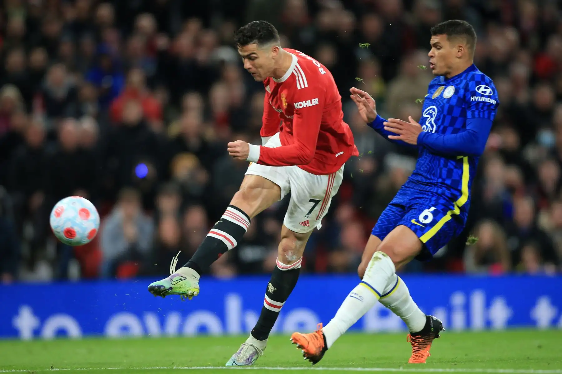 El delantero portugués del Manchester United, Cristiano Ronaldo (Izq.), remata al defensor brasileño del Chelsea, Thiago Silva (Der.), para marcar su primer gol durante el partido de fútbol de la Premier League inglesa entre el Manchester United y el Chelsea en Old Trafford, en Manchester, al noroeste de Inglaterra. AFP