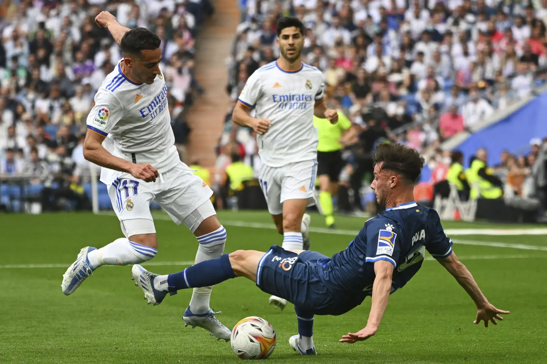 El delantero español del Real Madrid, Lucas Vázquez (L), lucha por el balón con el delantero español del Espanyol, Javi Puado, durante el partido de fútbol de la Liga española entre el Real Madrid CF y el RCD Espanyol en el estadio Santiago Bernabeu. Foto: AFP
