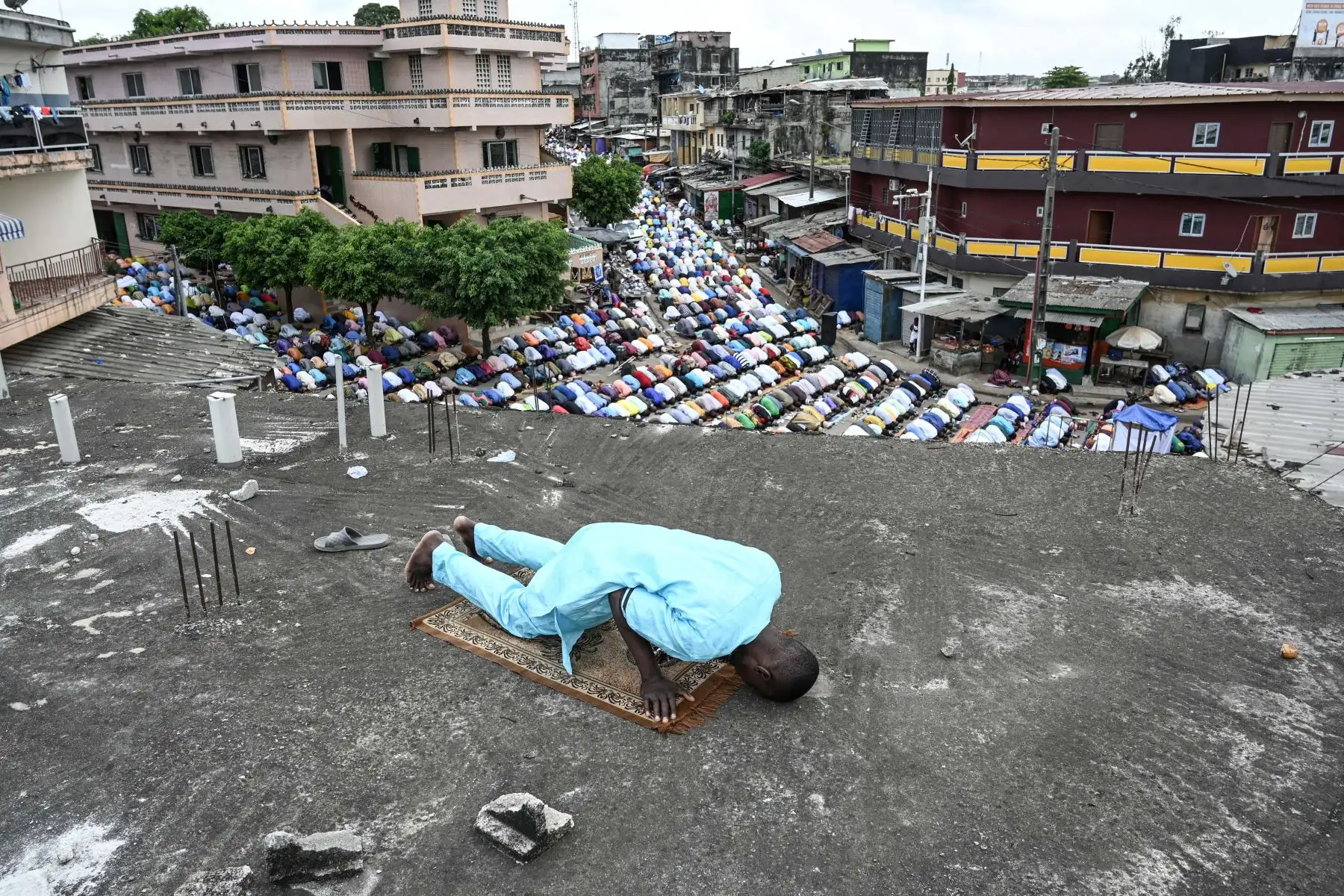 Un musulmán reza durante la oración matutina de Eid al-Fitr, que marca el final del sagrado mes de ayuno del Ramadán, en una azotea en Adjame, un distrito popular de Abiyán. Foto: AFP
