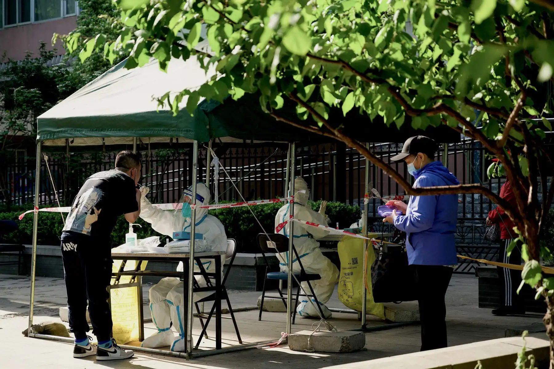 Trabajadores de la salud toman muestras de hisopos de personas para realizarles la prueba del coronavirus Covid-19 en un sitio de recolección de hisopos en Beijing. Foto: AFP