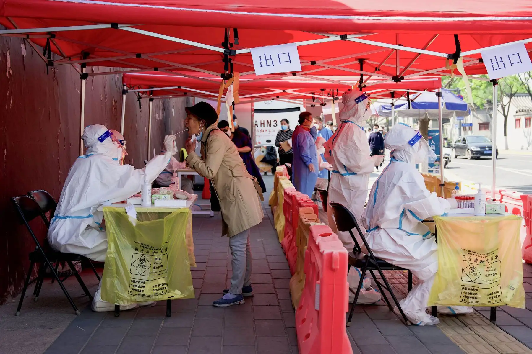 Un trabajador de la salud toma una muestra de hisopo de una mujer para analizarla por el coronavirus Covid-19 en un sitio de recolección de hisopos en Beijing. Foto: AFP