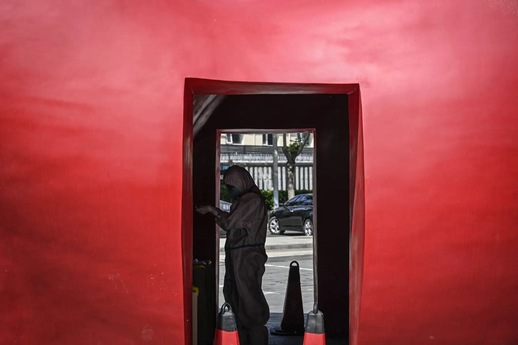 Un trabajador de la salud que usa equipo de protección personal es visto en un sitio de prueba improvisado afuera de un museo a lo largo de una calle en Beijing. Foto: AFP