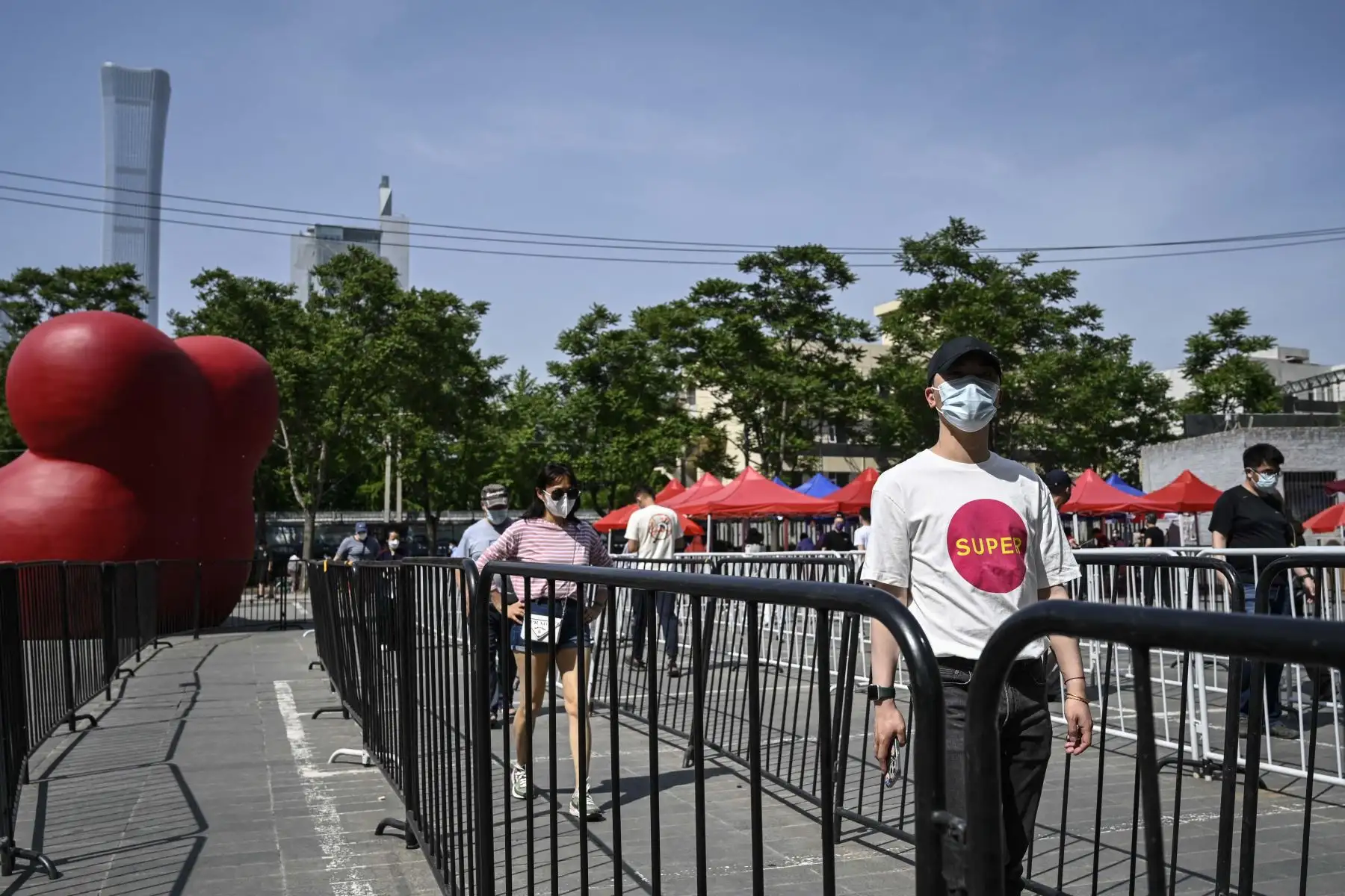 La gente hace cola para hacerse la prueba del coronavirus Covid-19 en un sitio de prueba improvisado afuera de un museo a lo largo de una calle en Beijing. Foto: AFP